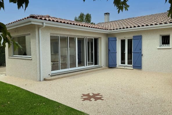 Une extension de maison en tuiles, ouverte sur les espaces extérieurs et sur une belle terrasse.