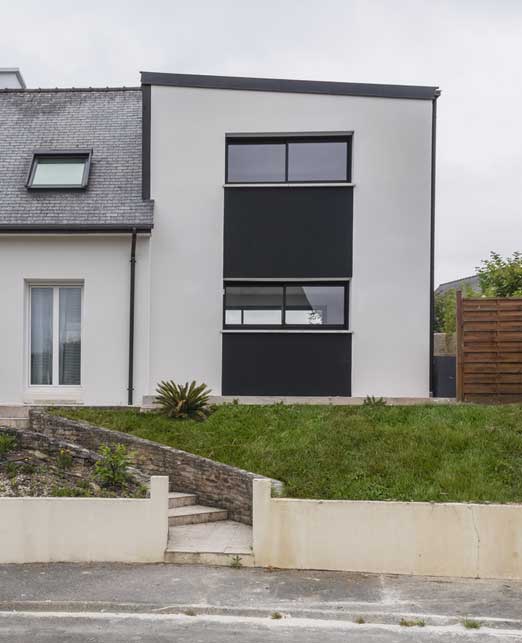 Une extension contemporaine à Vern sur Seiche avec des façades enduites en noir et blanc.